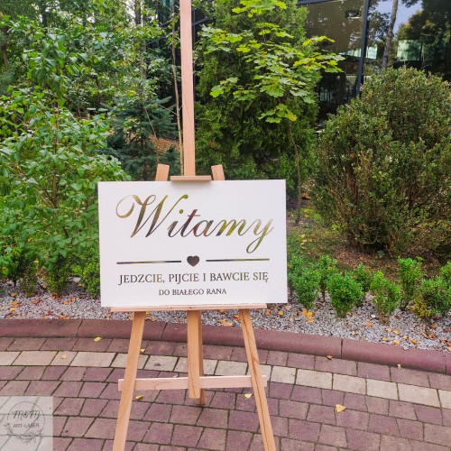 biała weselna tablica powitalna ze złotymi napisami w stylu glamour